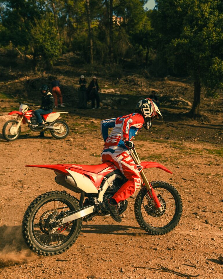 Dirt bike rider carving a turn on a sunny track