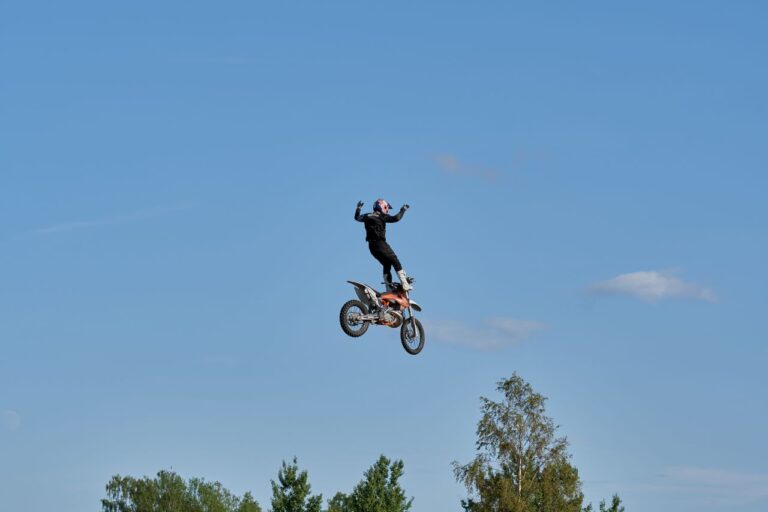 Motocross trick high against a blue sky