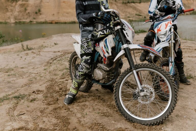 Two riders on electric-style dirt bikes on an off-road adventure