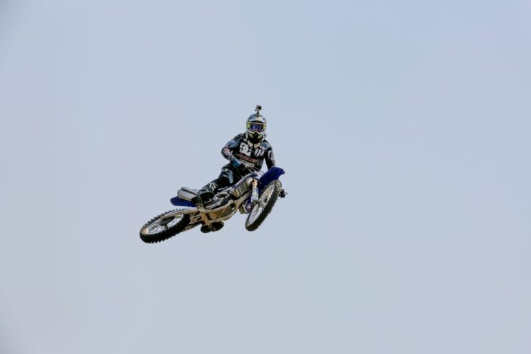 Dirt bike rider mid-air against a clear sky