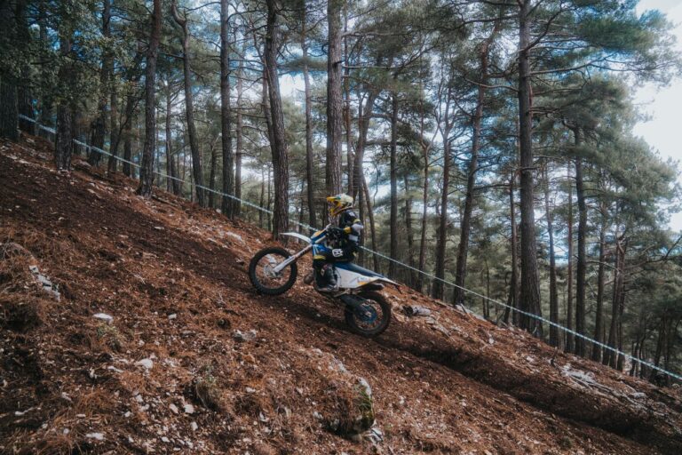 Enduro rider climbing a steep forest hill
