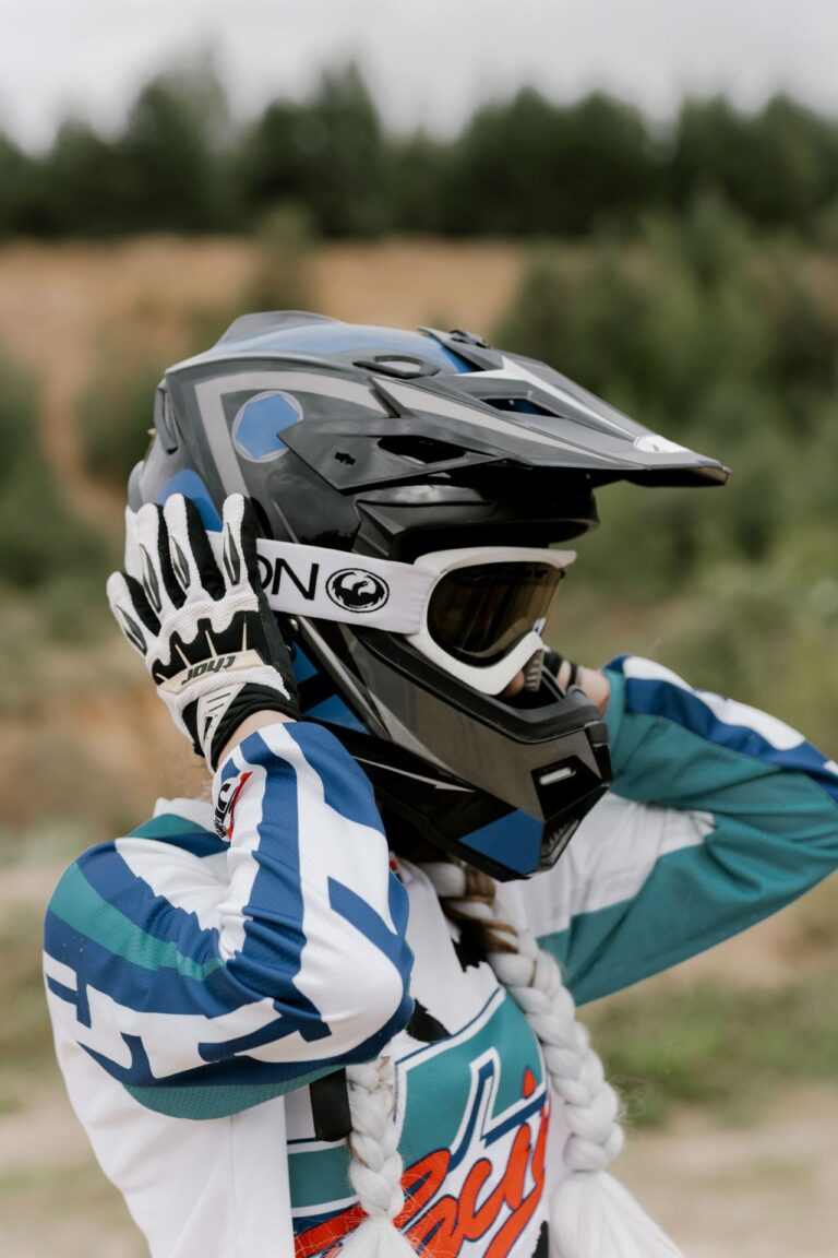 Rider adjusting a motocross helmet outdoors