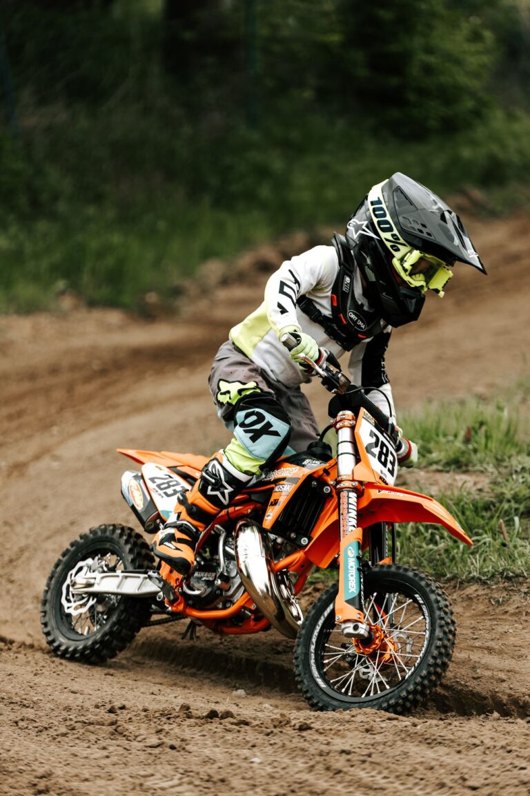 Young rider racing a dirt bike on a muddy track