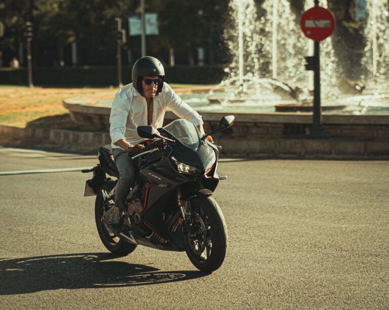 Rider with helmet resting beside a city fountain